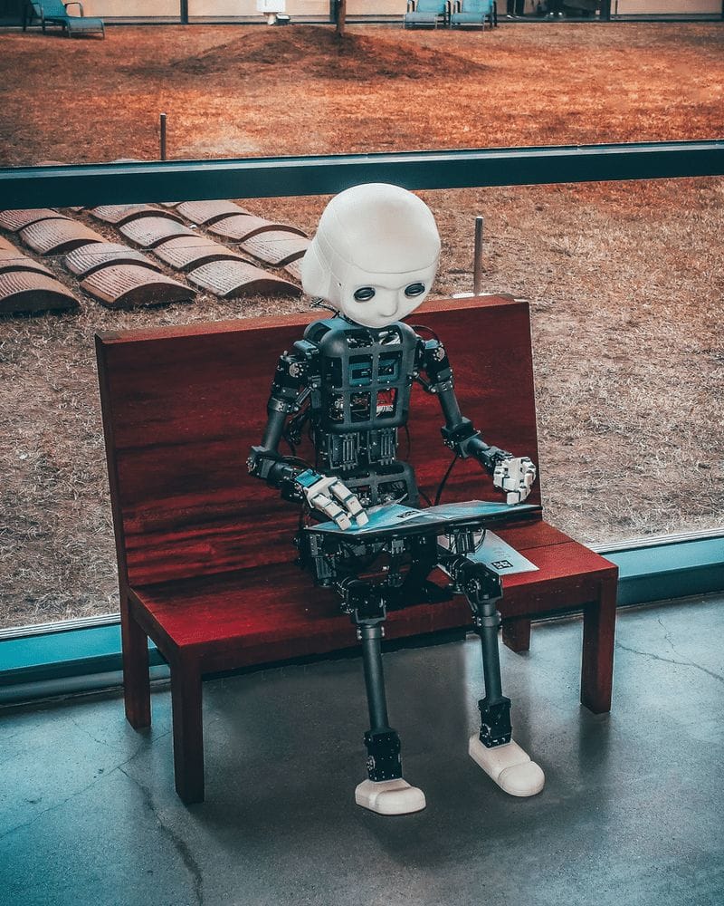 A robot figure sitting on a bench