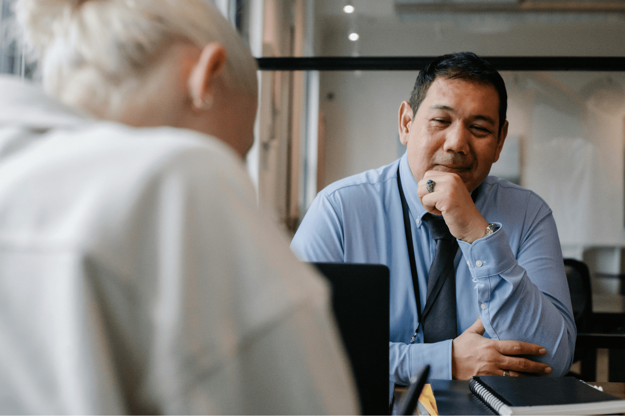 Two business professionals engaged in a one-on-one conversation during a meeting