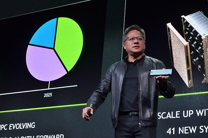Jensen Huang presenting at a conference in his trademark black leather jacket.