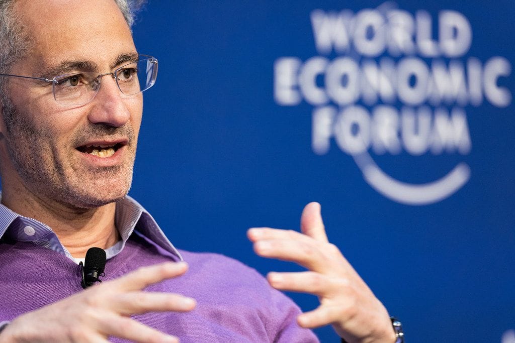 Business leader speaking at the World Economic Forum, sharing insights on stage during a panel discussion